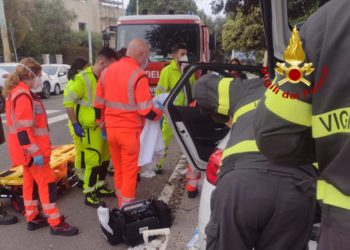 Incidente stradale di fronte alla Basilica Nostra Signora di Bonaria, a Cagliari, un vigile del fuoco libero dal servizio si adopera per i primi soccorsi