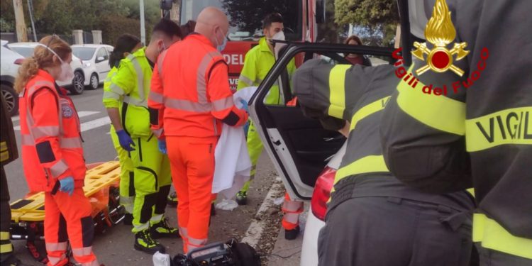 Incidente stradale di fronte alla Basilica Nostra Signora di Bonaria, a Cagliari, un vigile del fuoco libero dal servizio si adopera per i primi soccorsi
